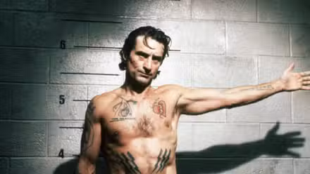 Max Cady with his arm outstretched for a mug shot in Cape Fear (1991)