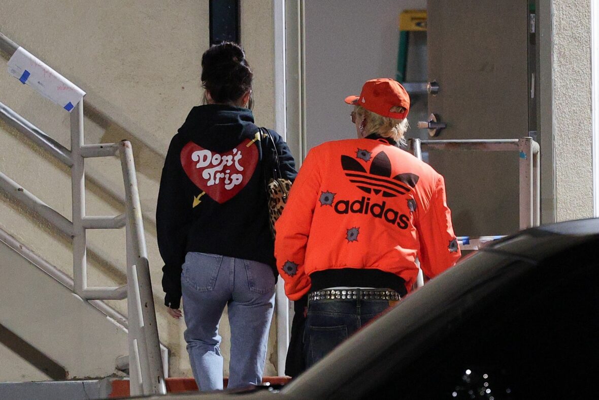 Dakota Johnson and Machine Gun Kelly seen at the studio on October 27, 2027 in Los Angeles, with their backs to the camera walking up the stairs