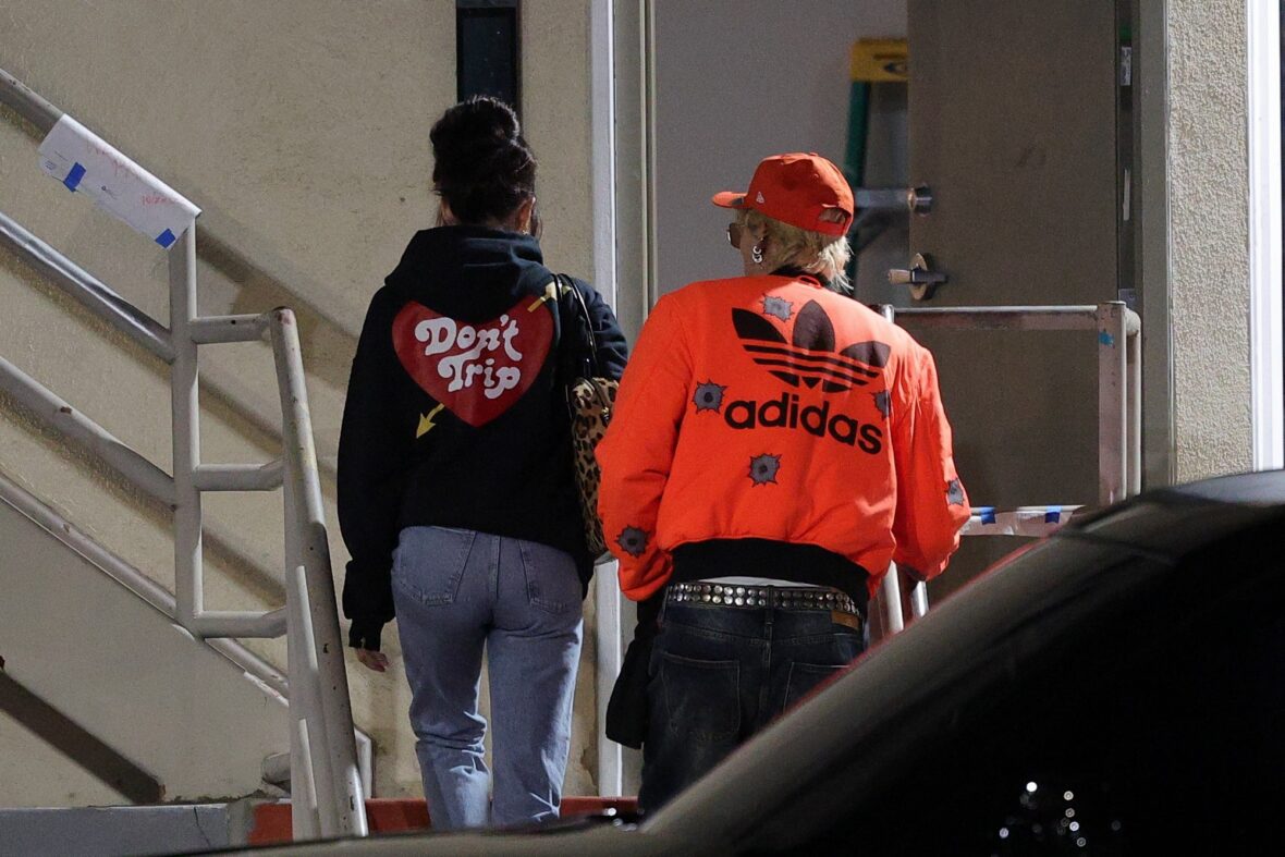 Dakota Johnson and Machine Gun Kelly seen at the studio on October 27, 2027 in Los Angeles, with their backs to the camera walking up the stairs