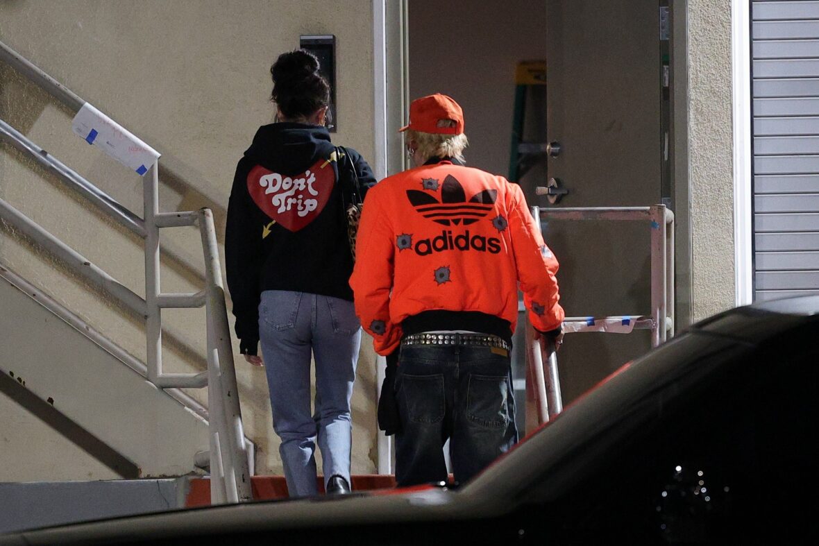 Dakota Johnson and Machine Gun Kelly seen at the studio on October 27, 2027 in Los Angeles, with their backs to the camera walking up the stairs