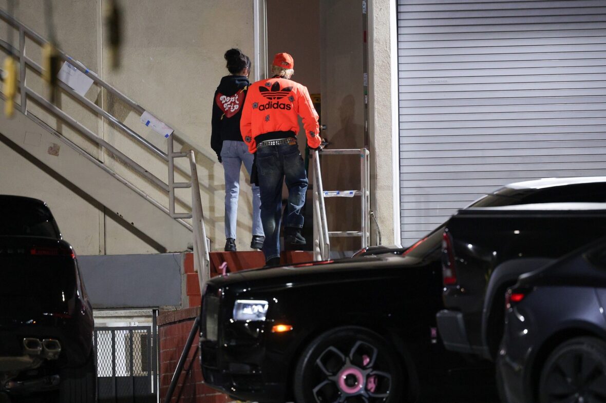 Dakota Johnson and Machine Gun Kelly seen at the studio on October 27, 2027 in Los Angeles, with their backs to the camera walking up the stairs