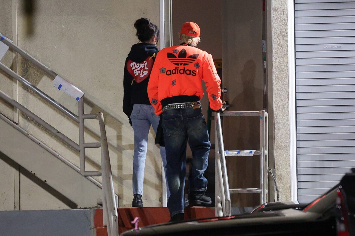Dakota Johnson and Machine Gun Kelly seen at the studio on October 27, 2027 in Los Angeles, with their backs to the camera walking up the stairs