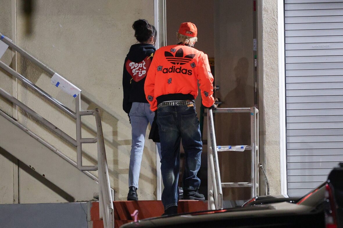 Dakota Johnson and Machine Gun Kelly seen at the studio on October 27, 2027 in Los Angeles, with their backs to the camera walking up the stairs
