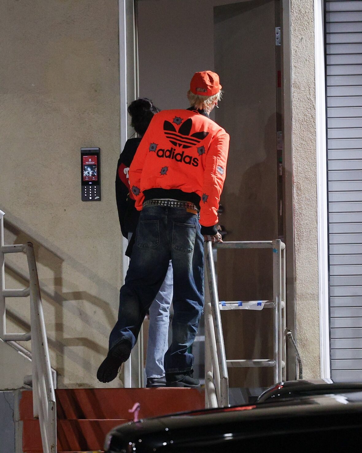 Dakota Johnson and Machine Gun Kelly seen at the studio on October 27, 2027 in Los Angeles, with their backs to the camera walking up the stairs